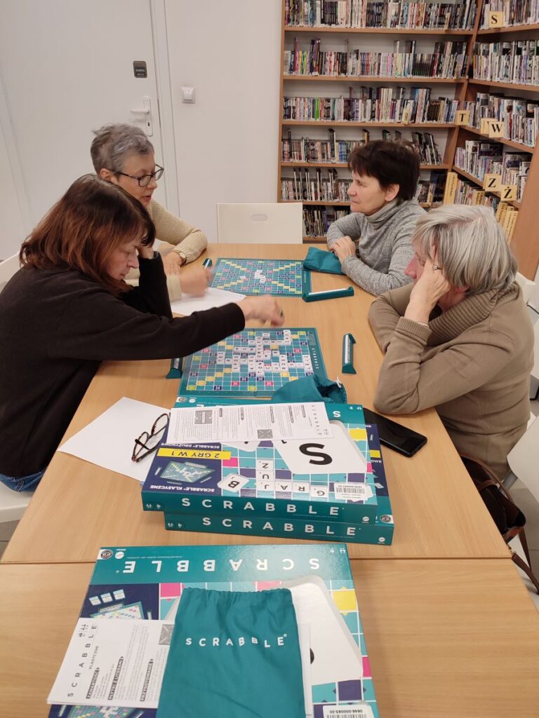 czytelnicy grają w scrabble w bibliotece