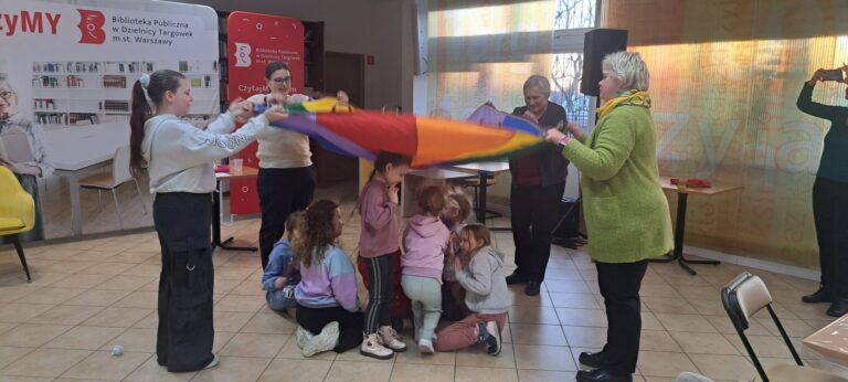 dzieci bawią się na kolorowej tkaninie