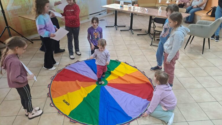 dzieci bawią się na kolorowej tkaninie