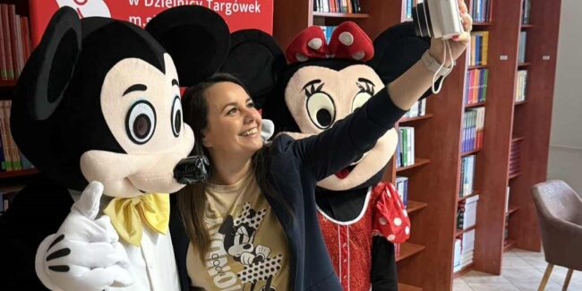 uczestniczka warsztatów robi sobie selfie z bajkowymi znanymi Myszkami - dużymi maskotkami