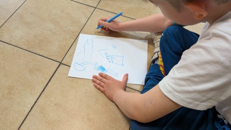 chłopiec rysuje na kartce