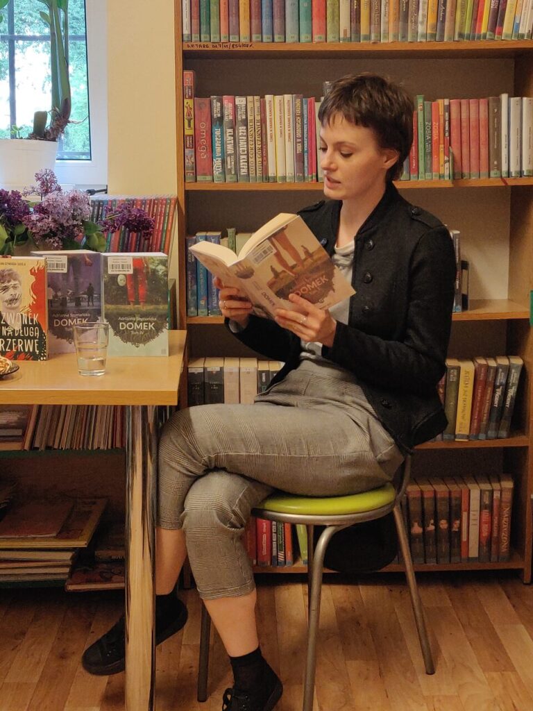 dwie kobiety siedzą przy stole podczas spotkania autorskiego