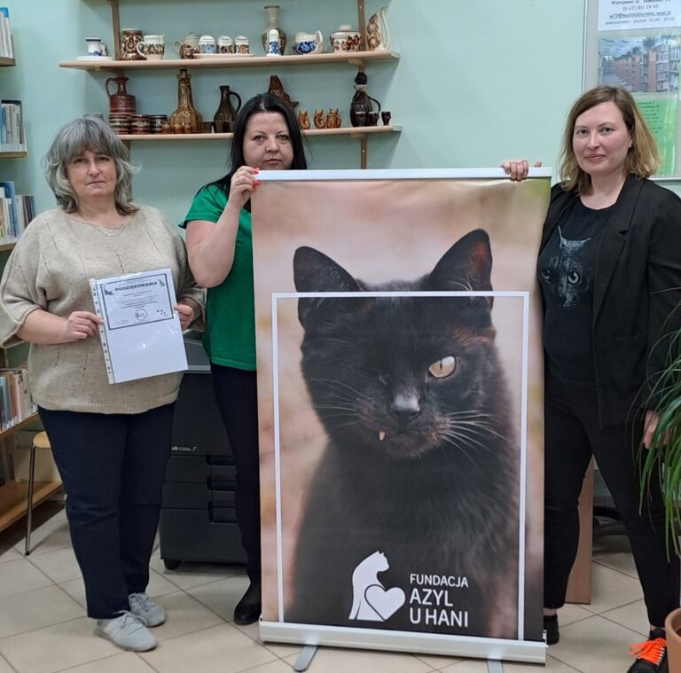 bibliotekarki trzymają plakat promujący zbiórkę dla schroniska dla zwierząt