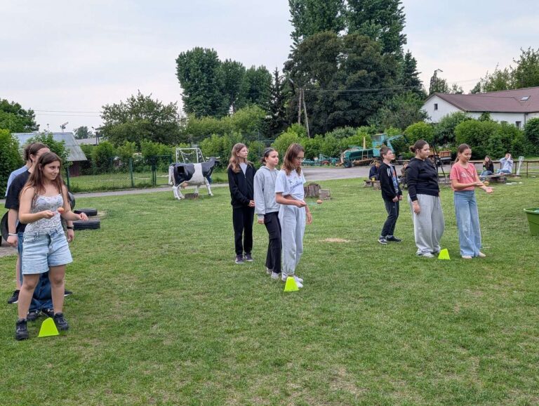 wolontariusze na trawie w folwarku