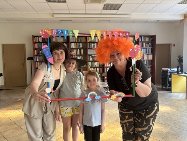 dzieci pozują do zdjęć, stojąc w kolorowej dużej ramce