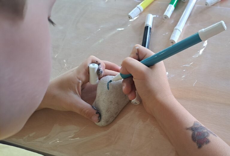 kolorowe kamyki pomalowane podczas warsztatów dla dzieci w bibliotece