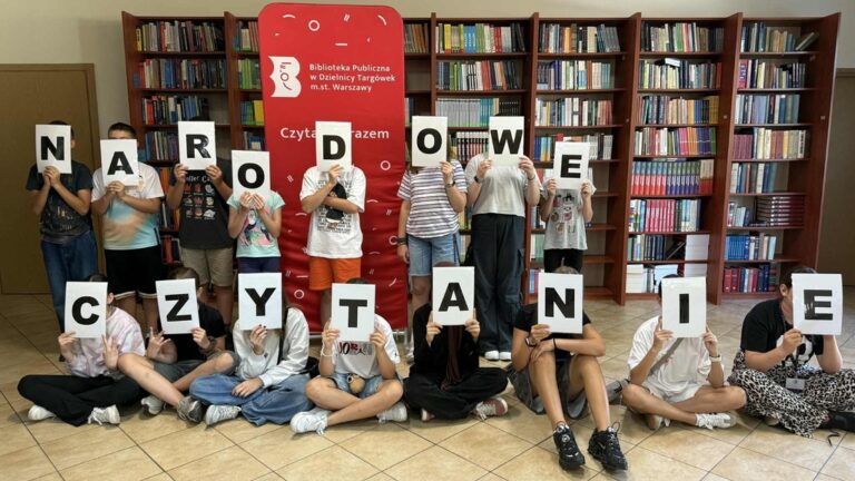 uczniowie szkoły podstawowej czytają w bibliotece fraszki Jana Kochanowskiego