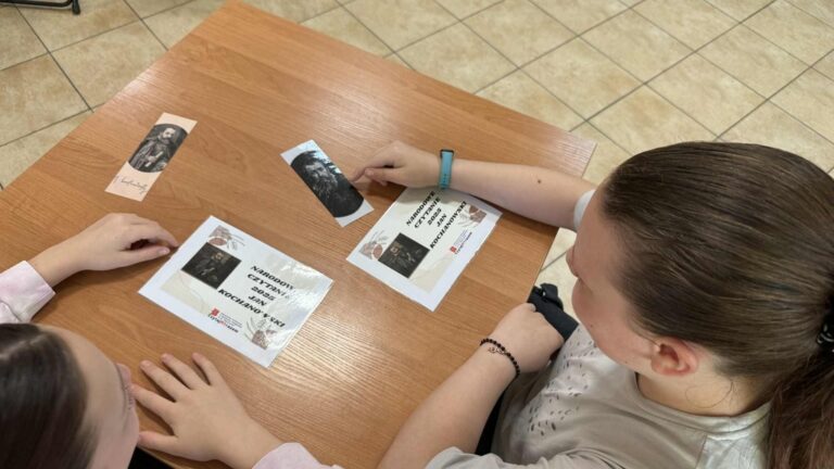 uczniowie szkoły podstawowej czytają w bibliotece fraszki Jana Kochanowskiego