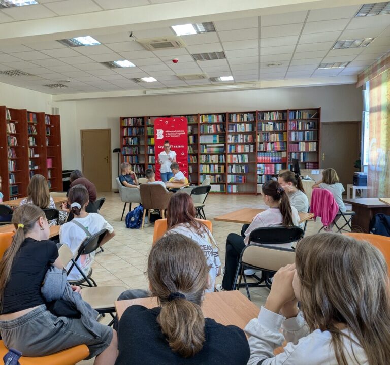 uczniowie szkoły podstawowej czytają w bibliotece fraszki Jana Kochanowskiego