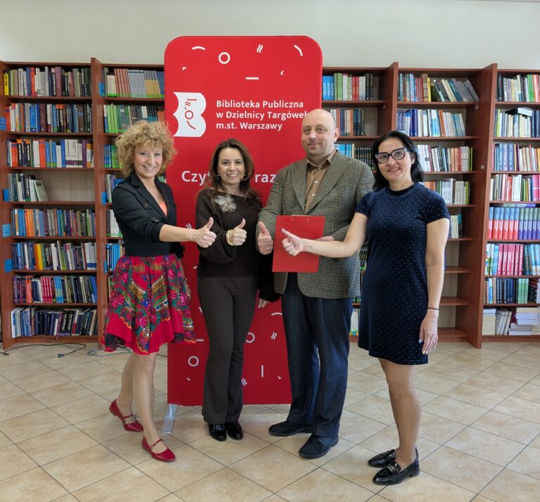 dyrekcja i pracownicy biblioteki pokazują kciukiem OK, uśmiechają się, ciesząc się z wygranego dofinansowania na realizację projektu