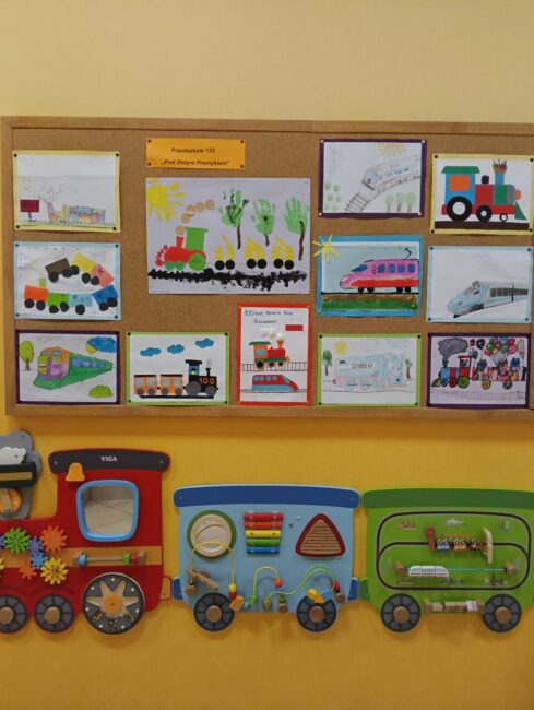 obrazki pociągów zdobiące ścianę biblioteki