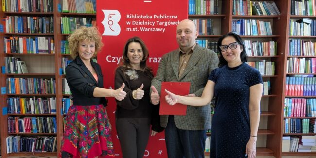 dyrekcja i pracownicy biblioteki pokazują kciukiem OK, uśmiechają się, ciesząc się z wygranego dofinansowania na realizację projektu
