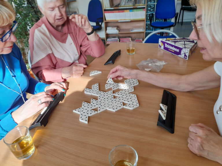 trzy osoby grają w gry Triominos i Rummikub