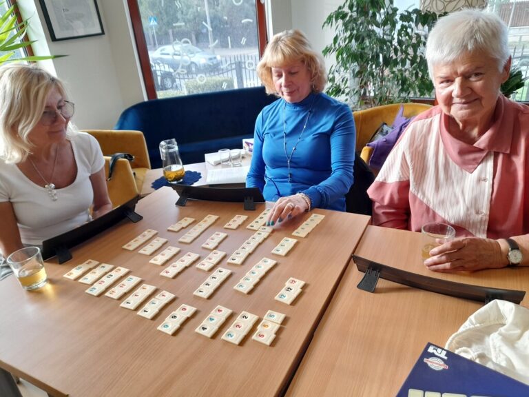 trzy osoby grają w gry Triominos i Rummikub