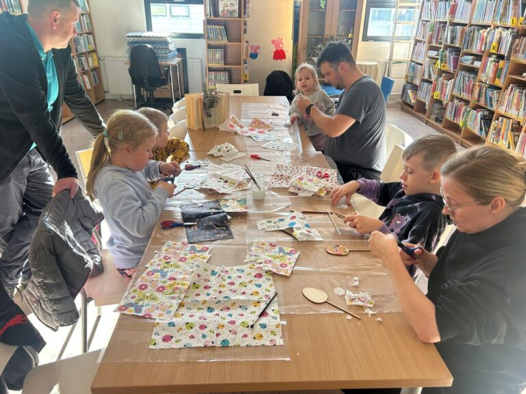 dzieci i dorośli tworzą zakładki do książek w bibliotece