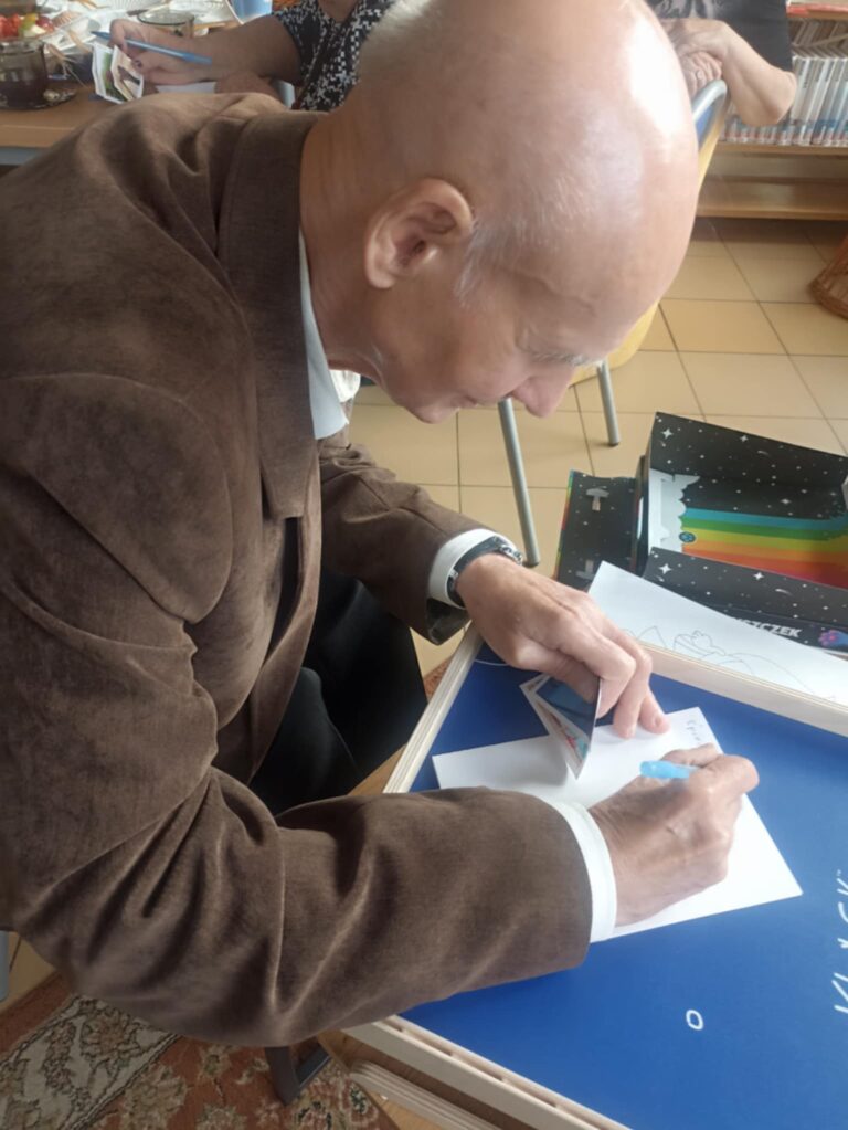 mężczyzna pisze wiersz w bibliotece