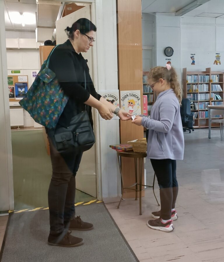 dzieci w bibliotece biorą udział w zabawie z nagrodami; odpowiadają na pytania dotyczące książek