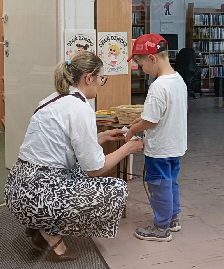 dzieci w bibliotece biorą udział w zabawie z nagrodami; odpowiadają na pytania dotyczące książek