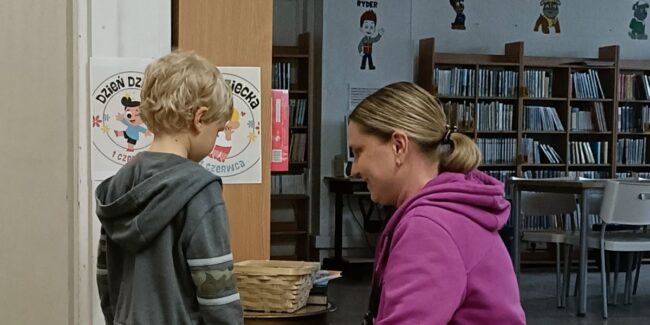 dzieci w bibliotece biorą udział w zabawie z nagrodami; odpowiadają na pytania dotyczące książek
