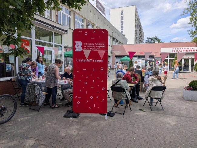 impreza plenerowa przed Czytelnią; dużo ludzi bierze udział w warsztatach decoupage i gra w bilard indyjski - carrom