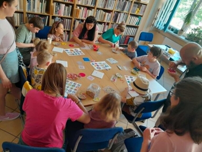 dzieci z rodzicami w bibliotece podczas zajęć kreatywnych