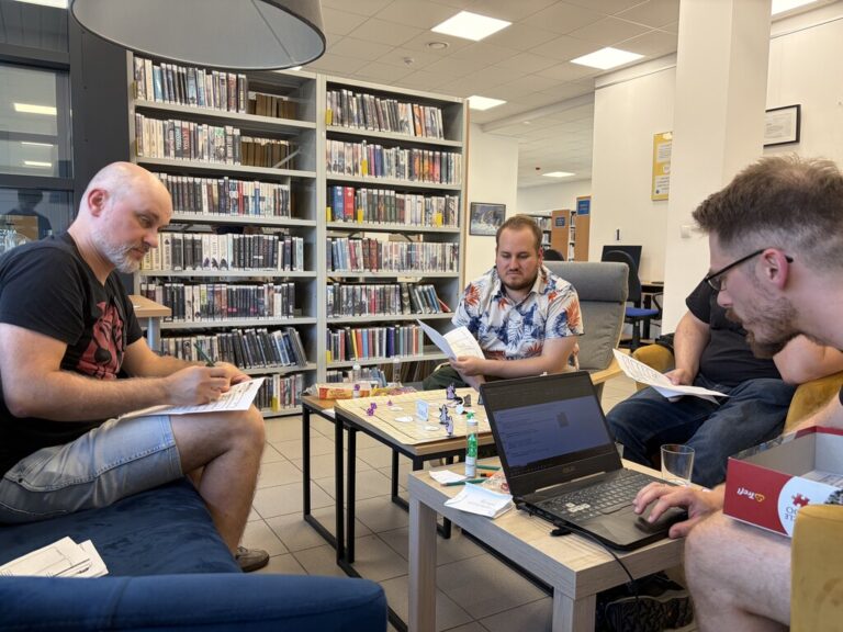 kilka osób siedzi przy stoliku w bibliotece - trwa sesja RPG